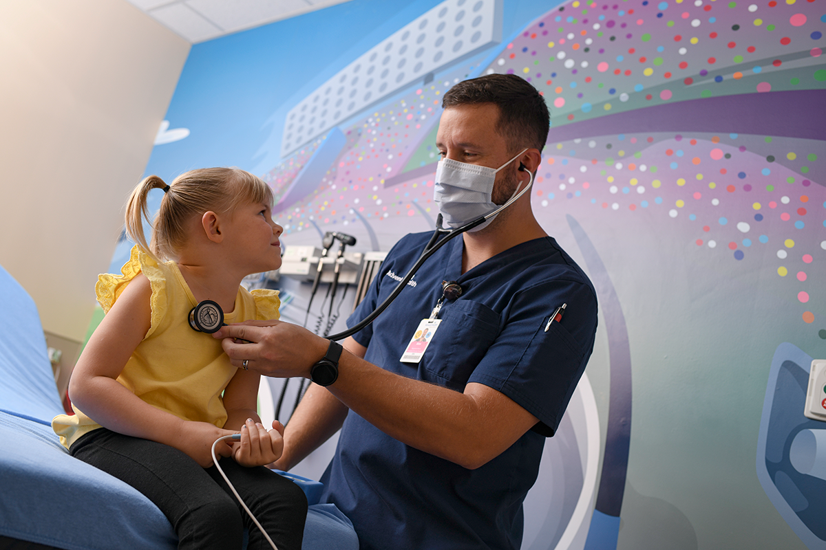 A healthcare worker performing a medical examination on a child using a stethoscope.