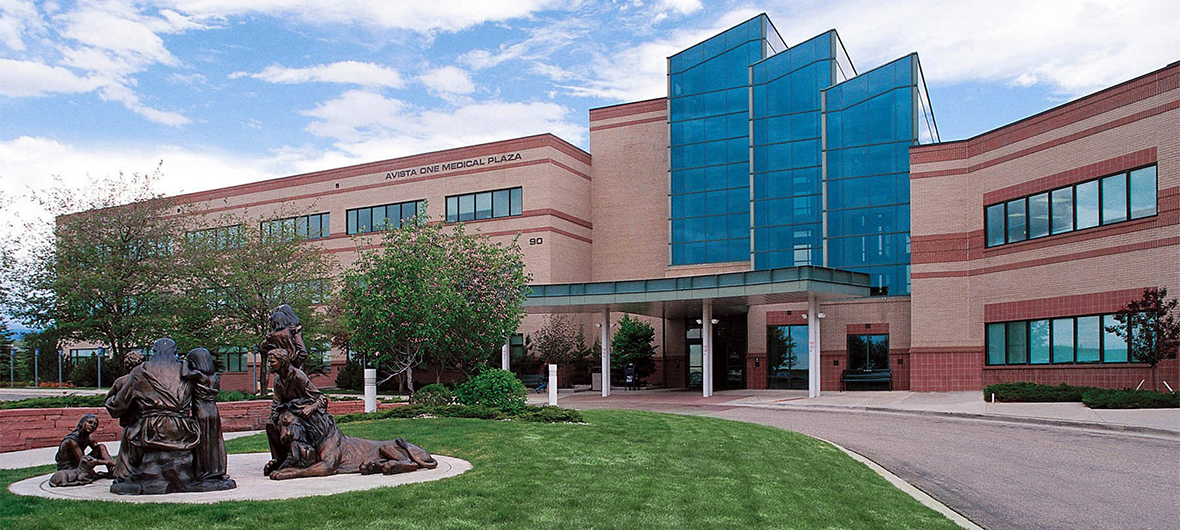 Exterior view of AdventHealth Avista Hospital, a modern medical building with large glass windows and a landscaped lawn in front.