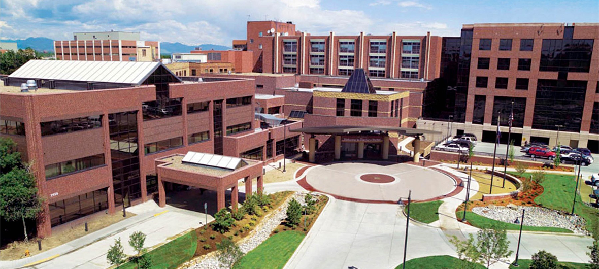 Exterior view of AdventHealth Porter hospital, a sprawling brick facility with an open courtyard and pathways in front.