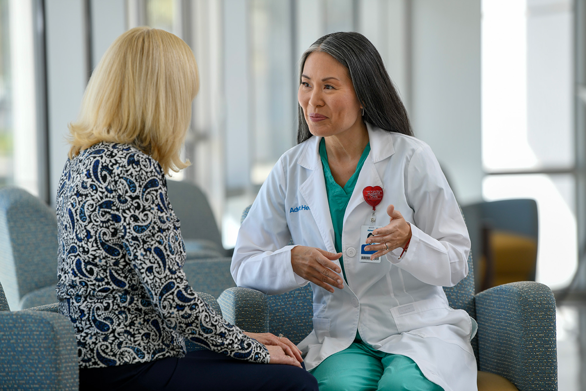 A patient discussing their health with a doctor while comfortably seated in a chair.