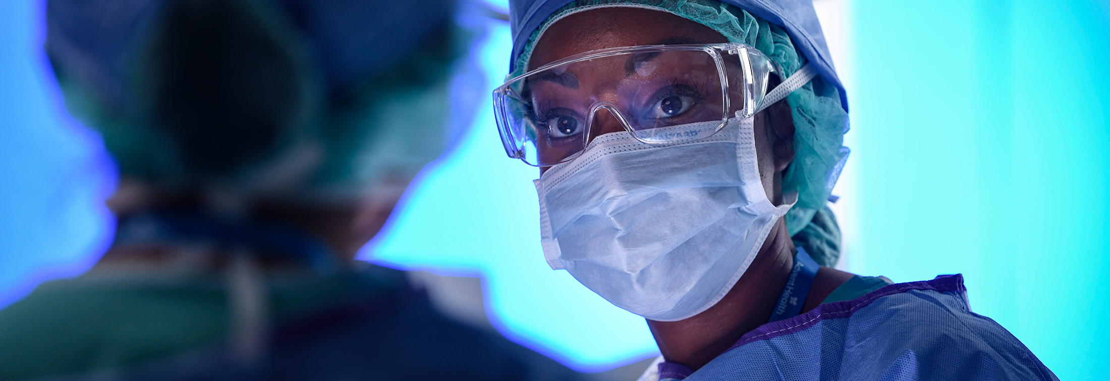 A surgeon wearing a surgical gown and mask, ready to perform a medical procedure.